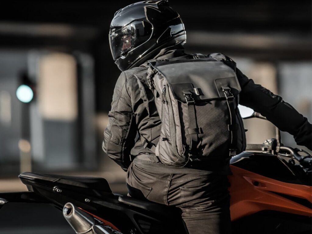 homme sur une moto avec un sac à dos
